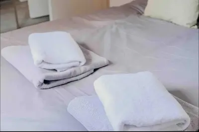 two stacks of towels on a white bed at Glasgow City - 1 Bedroom Apartment in Glasgow