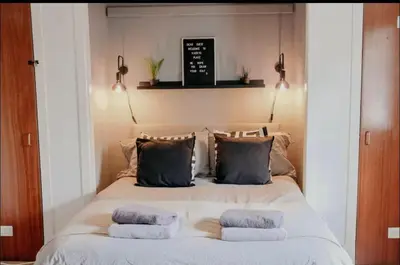 a bedroom with a bed with pillows on it at Glasgow - 1 Bedroom Apartment in Glasgow
