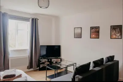 a living room with a couch and a tv at Glasgow - 1 Bedroom Apartment in Glasgow