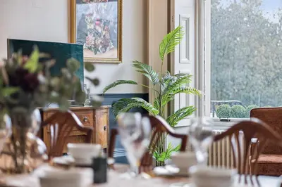 a dining room with a table with plants and a window at Grand 2 Bed West End Residence in Glasgow