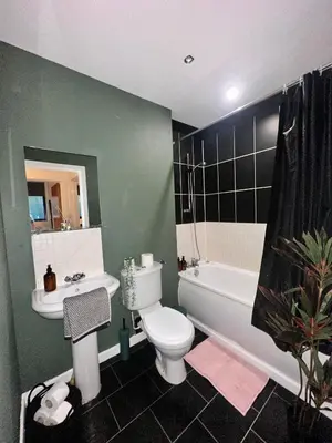 a bathroom with a toilet and a sink and a tub at Stylish 2 bed City Retreat in Glasgow