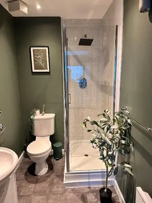 a bathroom with a shower with a toilet and a sink at Stylish 2 bed City Retreat in Glasgow