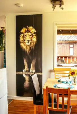a painting of a lion on a wall in a dining room at Wild Jungle Retreat in Kirn