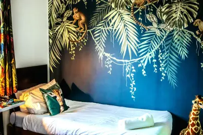a bedroom with a bed with a blue wall at Wild Jungle Retreat in Kirn
