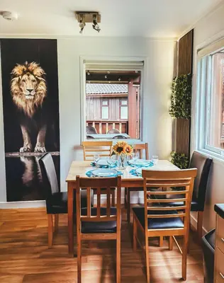 a dining room with a table with chairs and a lion painting at Wild Jungle Retreat in Kirn