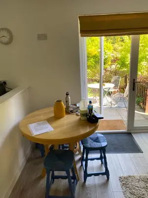 a table and chairs in a room with a patio at Garden flat in Largs