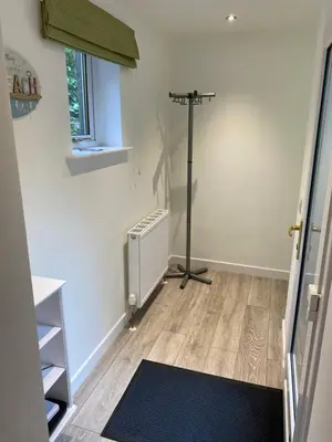 a room with a heater and a room with a floor at Garden flat in Largs