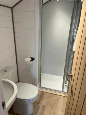 a bathroom with a toilet and a glass shower door at Pod at Lonan drive in Oban