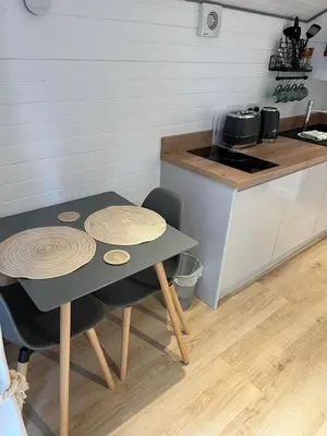 a kitchen with a table and two chairs and a counter at Pod at Lonan drive in Oban