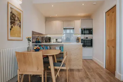 a kitchen with a table and chairs in a room at Scottish Apartment with Amazing Castle Views in Edinburgh