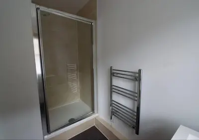 a shower with a glass door in a bathroom at Grassmarket Apartment with Amazing Castle View in Edinburgh
