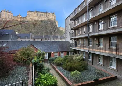 a view of a building with a castle in the background at Grassmarket Apartment with Amazing Castle View in Edinburgh