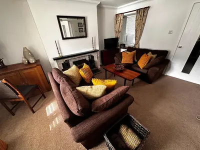 a living room with a couch and a fireplace at Thornhill cottage with views of the Trossachs in Thornhill