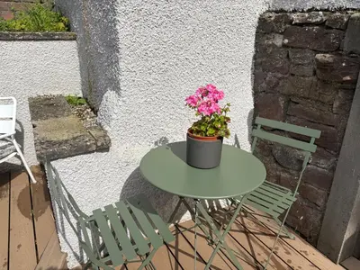 a table with a potted plant on it next to two chairs at 11 George Street Doune in Stirling
