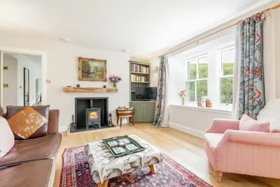 a living room with a couch and a fireplace at Burnside - gorgeous romantic cottage for 2 in Monzie