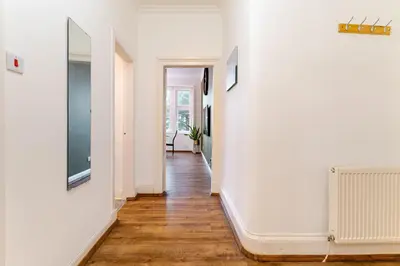 an empty hallway with white walls and wooden floors at Newly Furnished Flat 4 Minutes Walk To Metro in Glasgow