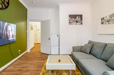 a living room with a couch and a refrigerator at Newly Furnished Flat 4 Minutes Walk To Metro in Glasgow