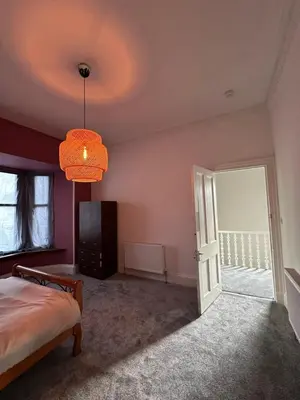 a bedroom with a bed and a chandelier at Spacious 5 Bedroom House Close to Central West End in Glasgow