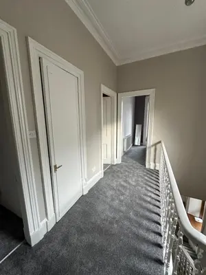 an empty hallway with stairs and doors in a building at Spacious 5 Bedroom House Close to Central West End in Glasgow