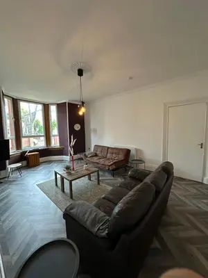 a living room with a couch and a table at Spacious 5 Bedroom House Close to Central West End in Glasgow