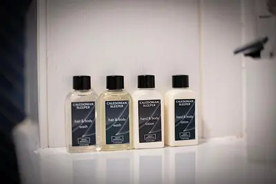 three bottles of laundry detergent sitting on a shelf at Charming 2 Bed Apartment in the heart of the West End in Glasgow