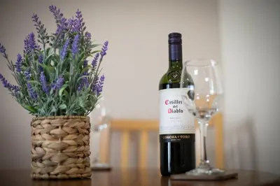 a bottle of wine sitting next to a wine glass at Charming 2 Bed Apartment in the heart of the West End in Glasgow