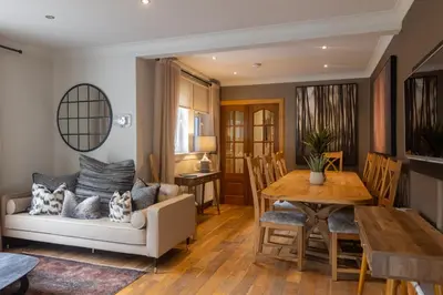 a dining room and living room with a table and a couch at Luss Cottages at Glenview in Luss