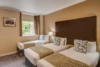 a hotel room with two beds and a window at New Lanark Self Catering Waterhouses in Lanark