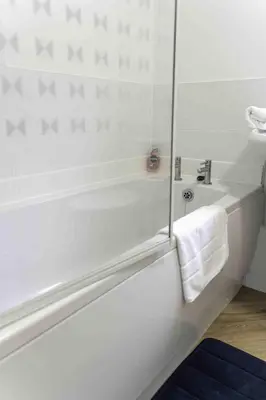 a white bathroom with a tub and a sink at 2 BDR House By Caledonia Luxe Stays Short Lets & Serviced Accommodation Glasgow in Glasgow