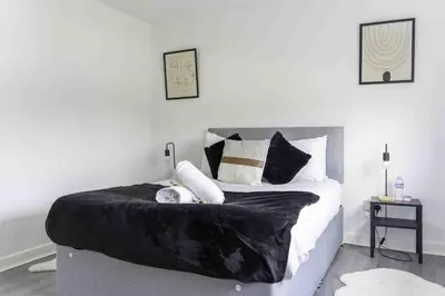 a bedroom with a bed with black and white pillows at 2 BDR House By Caledonia Luxe Stays Short Lets & Serviced Accommodation Glasgow in Glasgow