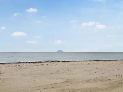 an empty beach with the ocean in the background at Beachcomber Apartment in Girvan