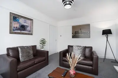 a living room with two brown couches and a table at 2-Bed Flat Wishaw Free Parking Family-Friendly in Wishaw