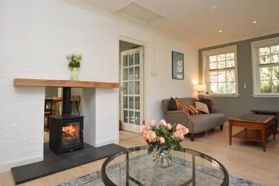 a living room with a fireplace and a couch at Old Powdermill Cottage in Tighnabruaich