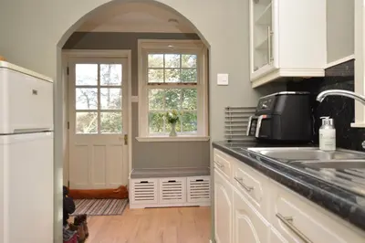 a kitchen with an archway and a sink and a window at Old Powdermill Cottage in Tighnabruaich