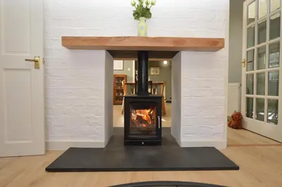 a fireplace in a living room with a wood stove at Old Powdermill Cottage in Tighnabruaich