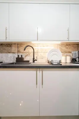 a kitchen with white cabinets and a sink at The Pad in Paisley