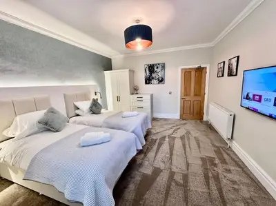 a bedroom with two beds and a flat screen tv at Spectacular 2 bed, 2 bath in Edinburgh City Centre in Edinburgh