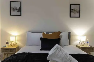 a bedroom with a bed with pillows and two lamps at Montgomery Avenue in Paisley