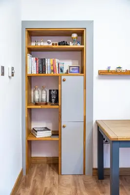 a book shelf with a white door next to a desk at Large bedroom, close to Airport and City Centre in Edinburgh