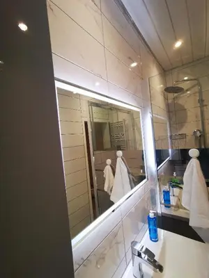 a bathroom with a mirror and a sink with towels at Large bedroom, close to Airport and City Centre in Edinburgh