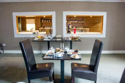 a dining room with a table and two chairs at Helix Hotel in Grangemouth