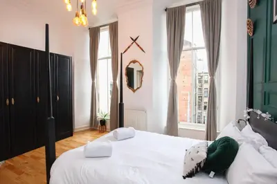 a bedroom with a large white bed and a window at Lovely spacious 2 Bed Flat in Glasgow