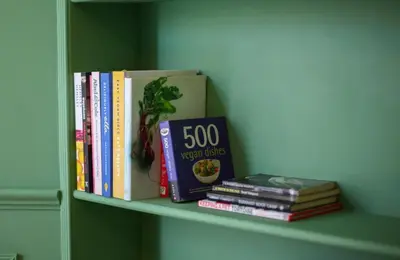 a shelf with some books sitting on it at Lovely spacious 2 Bed Flat in Glasgow