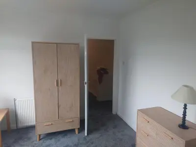a bedroom with a wooden cabinet and a closet at 3 bedroom terraced house in Larkhall