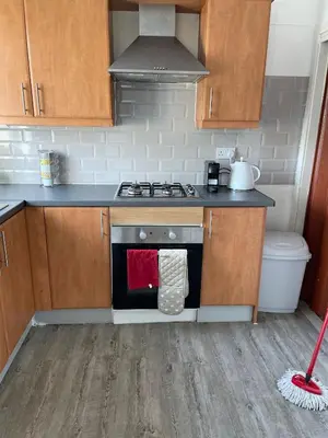 a kitchen with a stove with a red towel on the oven at 3 bedroom terraced house in Larkhall