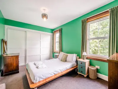 a green bedroom with a bed and a window at Springvale in Cardross