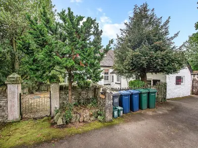 a fence with trash cans in front of a house at Springvale in Cardross