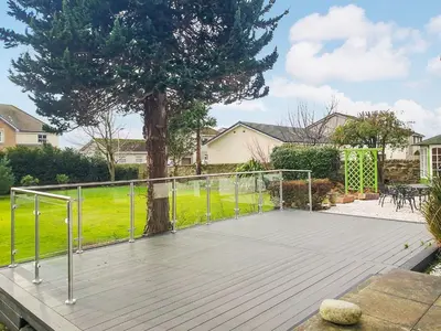a wooden deck with a tree in a yard at Springvale in Cardross