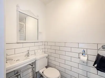 a white bathroom with a toilet and a sink at Springvale in Cardross