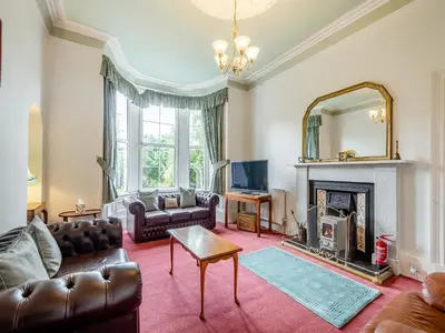 a living room with a couch and a fireplace at Springvale in Cardross